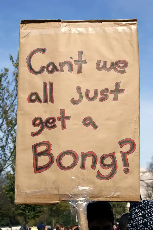 Schild eines Demonstranten, Aufschrift: „Can't we all just get a Bong?